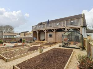 a garden with a greenhouse in the back of a house at Tree Tops in Witney