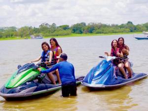 Águila Dorada Selva Hotel في بوكالبا: مجموعة من الأشخاص يركبون الجت سكي في الماء