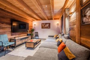 a living room with a couch and a tv at Chalet Izoard in Saint-Chaffrey