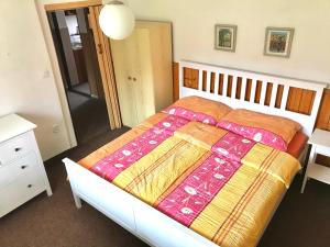 ein Schlafzimmer mit einem Bett mit einer Decke darauf in der Unterkunft Apartmán Na Kopečku in Modrava