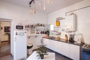 cocina con armarios blancos y nevera en Barbieri Sol Hostel, en Madrid