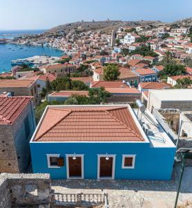 a blue house with a red roof in a city at Althea Apartments 1 in Halki