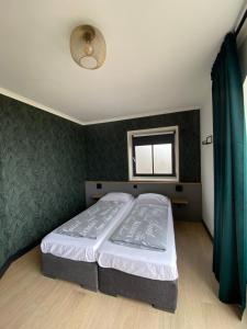 ein Schlafzimmer mit einem Bett mit einer grünen Wand in der Unterkunft Buitenplaats Langewijk in Zuidoostbeemster