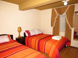 ein Schlafzimmer mit zwei Betten und einem Fenster in der Unterkunft Hotel Jumari in Uyuni