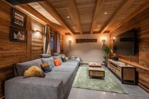 a living room with a couch and a flat screen tv at Chalet Galibier in Saint-Chaffrey