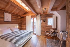 a bedroom with a bed in a room with wooden walls at Chalet Galibier in Saint-Chaffrey
