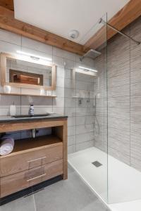 a bathroom with a shower with a sink and a glass door at Chalet Galibier in Saint-Chaffrey