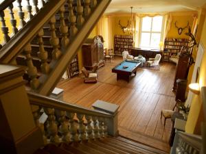 einen Blick über ein Wohnzimmer mit einer Treppe in der Unterkunft Jagdschloss Quitzin in Grimmen