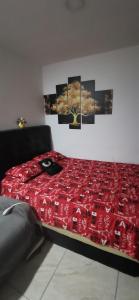 メデジンにあるApartamento vacacional en Medellín central privado y tranquiloの赤い掛け布団付きのベッド1台