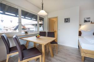 ein Esszimmer mit einem Tisch, Stühlen und einem Bett in der Unterkunft Ferienwohnung Bakker in Oberstdorf
