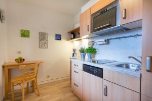 eine kleine Küche mit einem Waschbecken und einem Tisch in der Unterkunft Ferienwohnung Bakker in Oberstdorf