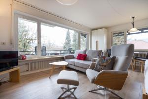 a living room with a couch and chairs and a tv at Ferienwohnung Bakker in Oberstdorf