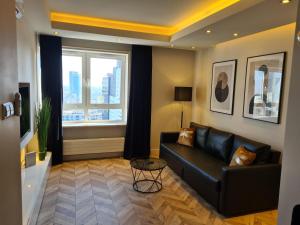 uma sala de estar com um sofá preto e uma janela em Platinum Towers Apartment with Parking by Renters Prestige em Varsóvia
