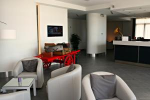 uma sala de estar com uma mesa vermelha e cadeiras em Castelmartini Wellness & Business Hotel em Larciano
