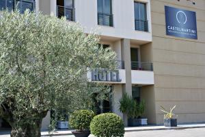 ein Hotelgebäude mit einem Baum davor in der Unterkunft Castelmartini Wellness & Business Hotel in Larciano