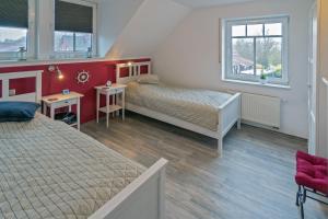 a bedroom with two beds and two windows at Leuchtturm in Dornumergrode