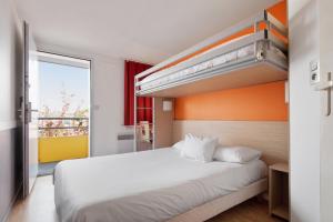 een slaapkamer met een wit bed en een bovenste stapelbed bij Premiere Classe Lyon Est - Bron Eurexpo in Décines-Charpieu