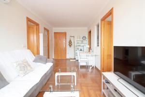 ein Wohnzimmer mit einem weißen Sofa und einem Tisch in der Unterkunft Global Properties, Apartamento Ideal Familias en Canet Playa in Canet d'en Berenguer