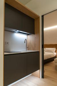 eine Küche mit einem Waschbecken und ein Bett in einem Zimmer in der Unterkunft Civitaloft Luxury Rooms in Civitanova Marche