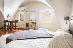 una camera con letto e una sala da pranzo con tavolo di Faro Bianco Gallipoli - Suites & Apartments a Gallipoli