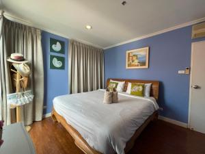 een slaapkamer met blauwe muren en een bed met kussens bij Baan Sanploen Hua Hin- Luxury Two Bedrooms in Hua Hin