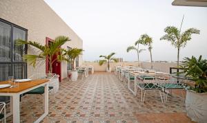 un restaurant avec des tables, des chaises et des palmiers dans l'établissement Treebo Tryst Median Inn, à Nagpur