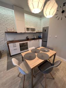 a kitchen with a wooden table and some chairs at Apartament Byka in Poznań