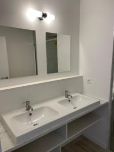 a bathroom with a white sink and a mirror at Gallery Apartment in Blankenberge