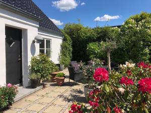 un patio con flores y plantas frente a una casa en Helts B&B - Helts Guesthouse, en Herning