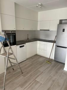 a kitchen with a broom and a refrigerator at Gallery Apartment in Blankenberge