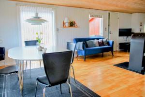 un soggiorno con un tavolo e un divano blu di The Little Red Cabin Near Blåvand! a Blåvand Altre 8 foto