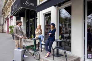 um homem e uma mulher em pé fora de uma loja com uma bicicleta em L'Hôtel em Nantes