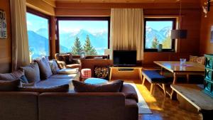 a living room with couches and a view of mountains at Ferienhaus Gipfelglück in Hygna