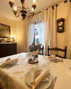 a dining table with a white table cloth and a clock at B&B Azalea in Cannobio