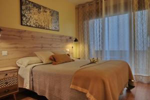 um quarto com uma cama grande e uma janela em Mi Isabelita em Arévalo