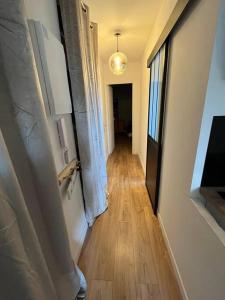 a hallway of a room with a wooden floor and a window at Joli T2 refait à neuf in Fréjus