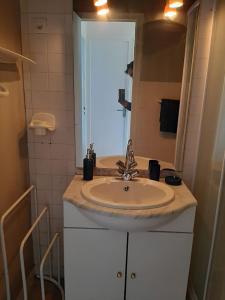 uma casa de banho com um lavatório e um espelho em location appartement 100 m de la plage em Pénestin