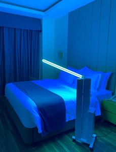 a bedroom with a bed with a blue light on it at Bravo Tanauan Hotel in Tanauan