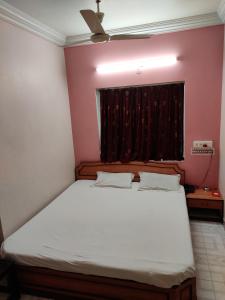 Un pat sau paturi într-o cameră la Hotel Tirupati
