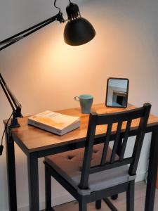 a desk with a lamp and a book and a mirror at Gîte L'Equilibre - Lac/montagnes- Familles-groupes in Kruth