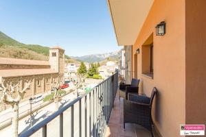 a balcony with chairs and a view of a city at Apartament Tritó - Rústico y acogedor con vistas - 2p in Guardiola de Berguedà