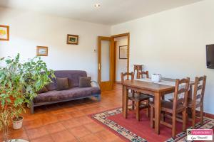 a living room with a table and a couch at Apartament Tritó - Rústico y acogedor con vistas - 2p in Guardiola de Berguedà