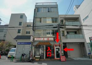 大阪市にあるYeah Room Nambaの前に赤い看板がある建物