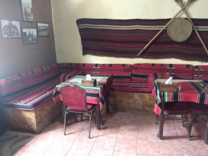 a restaurant with red tables and chairs in a room at Queen Ayloa Hotel&Restaurant in Madaba
