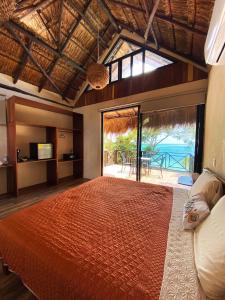 een slaapkamer met een groot bed en uitzicht op de oceaan bij Villas Mandarina Bacalar in Bacalar