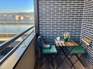 a table and chairs on a balcony with a view of the water at Gran Bilbao XI with parking by Aston Rentals in Barakaldo