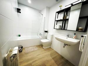 a white bathroom with a sink and a toilet at Gran Bilbao XI with parking by Aston Rentals in Barakaldo