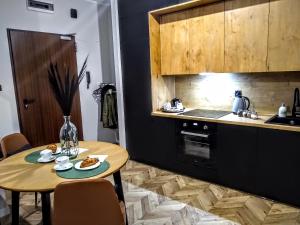 Una cocina con una mesa con comida encima. en EvitaDeLux Słowackiego 50mGaleria Katowice, en Katowice 26 fotos más