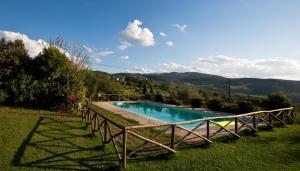 a swimming pool in a field with mountains in the background at Agriturismo Podere Acqualoreto in Acqualoreto