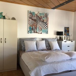 a bedroom with a bed with a painting of zebras at Auszeit am See in Langenargen